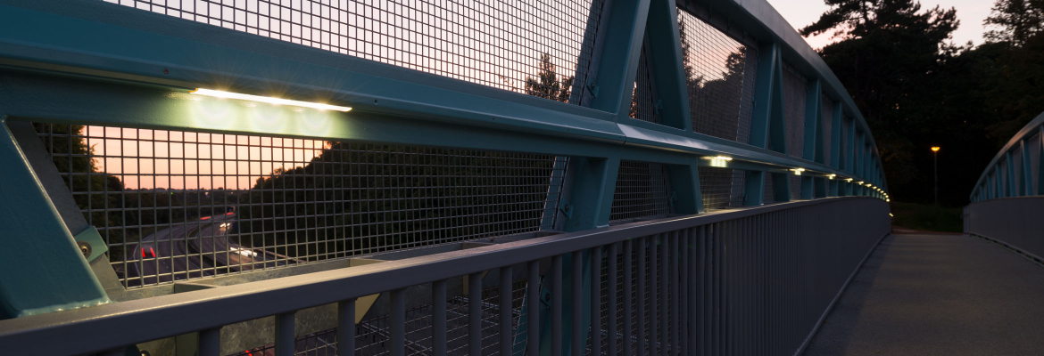 Anti-climb handrail lighting on public footbridge over road at night time