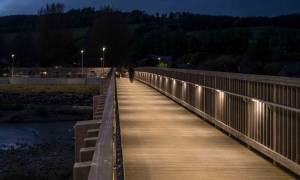 Pedestrian footbridge at night time lit by illuminated handrail